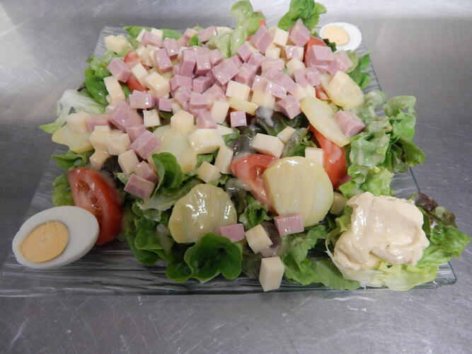 Salade, tomate, pomme de terre, dés de jambon, d'emmental, oeuf dur et mayonnaise